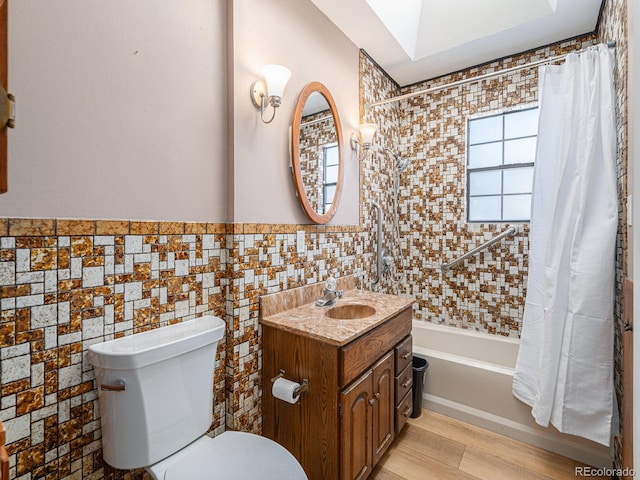 full bathroom featuring hardwood / wood-style flooring, tile walls, vanity, toilet, and shower / bath combo with shower curtain