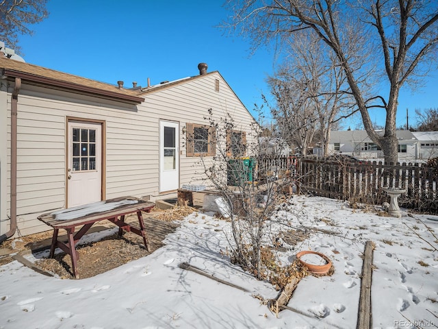 view of snow covered rear of property