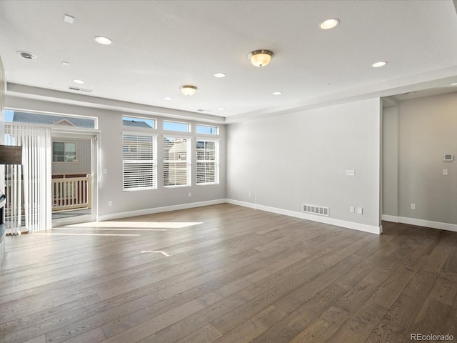 unfurnished room featuring dark wood-style floors, baseboards, visible vents, and recessed lighting