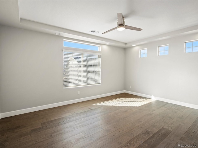 spare room featuring ceiling fan, wood finished floors, visible vents, and baseboards