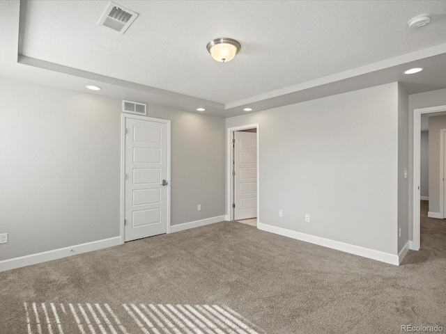 unfurnished room featuring carpet floors, visible vents, and baseboards