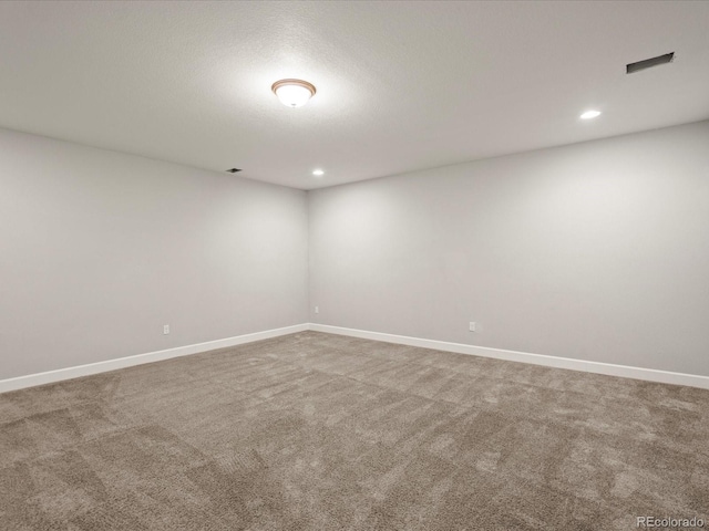 spare room featuring recessed lighting, carpet flooring, and baseboards