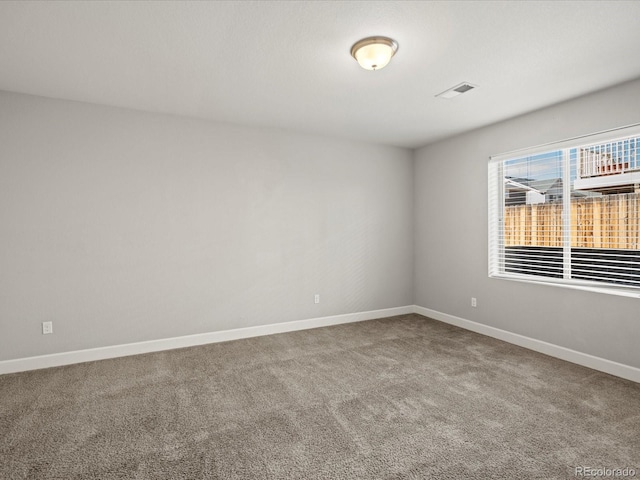 carpeted empty room with visible vents and baseboards