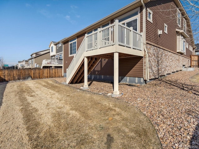 back of house with crawl space, stairs, fence, a deck, and brick siding