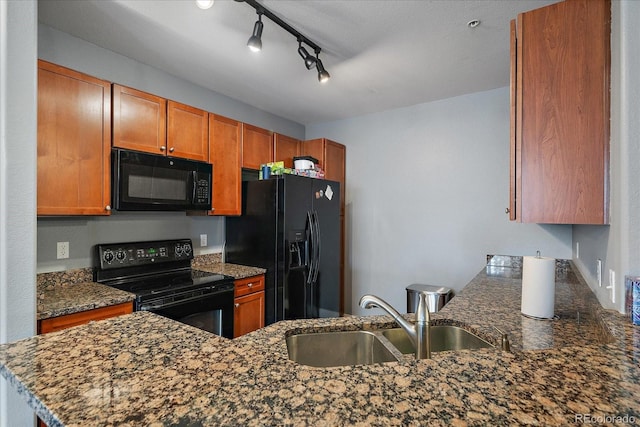 kitchen with dark stone counters, kitchen peninsula, sink, and black appliances