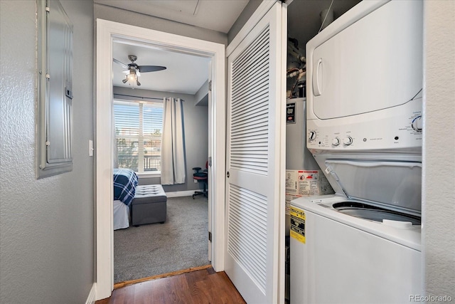 laundry area featuring dark hardwood / wood-style flooring, ceiling fan, and stacked washing maching and dryer