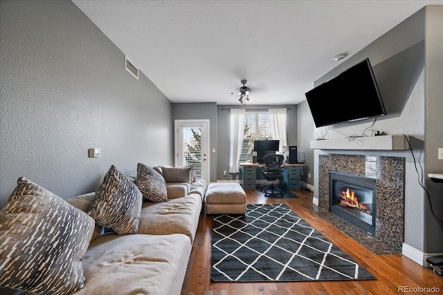 living room featuring a high end fireplace and wood-type flooring