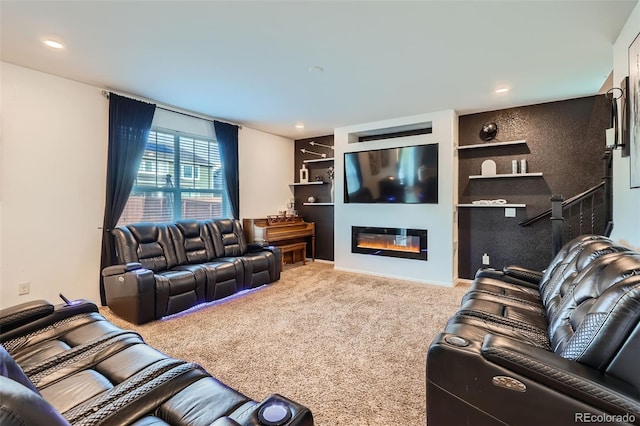 carpeted living area with built in features, a glass covered fireplace, and recessed lighting