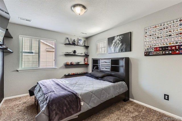 carpeted bedroom featuring baseboards and a textured ceiling
