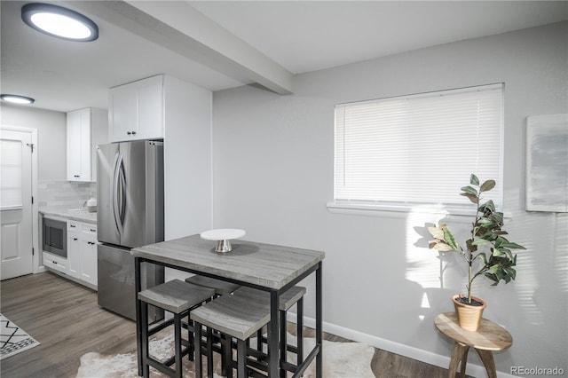 kitchen with dark hardwood / wood-style flooring, white cabinets, and appliances with stainless steel finishes