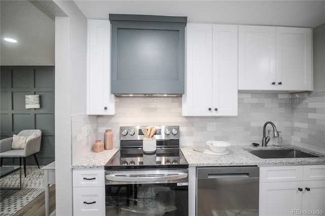 kitchen with sink, decorative backsplash, light stone countertops, white cabinetry, and stainless steel appliances