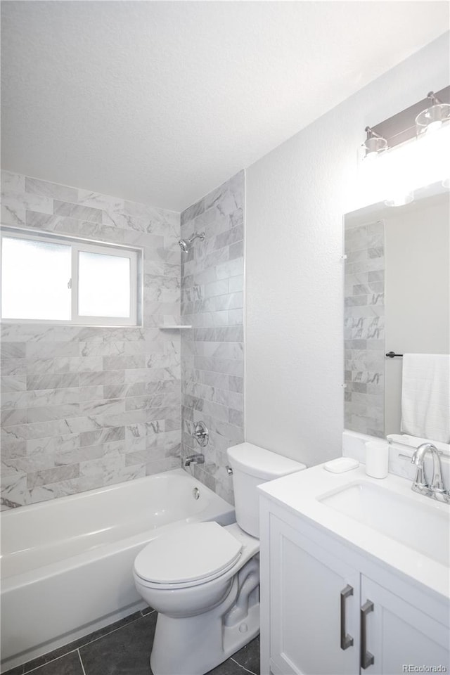 full bathroom featuring tile patterned floors, vanity, tiled shower / bath combo, and toilet