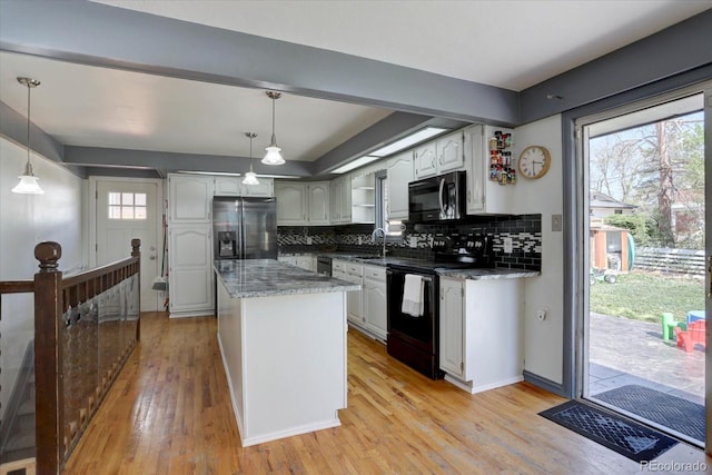 1641 Orchard Dr, Denver, CO 80221 - kitchen featuring black appliances, backsplash, light wood-style floors, and plenty of natural light