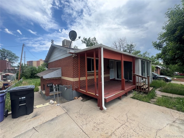 888 Wolff St, Denver, CO 80204 - rear view of house with brick siding, a wooden deck, and a patio