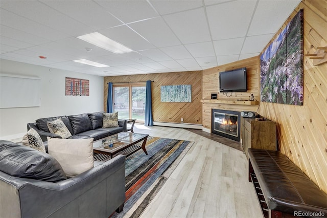 200 Granite St Unit 202, Frisco, CO 80443 - living area with wooden walls, a baseboard heating unit, a fireplace, wood finished floors, and a paneled ceiling