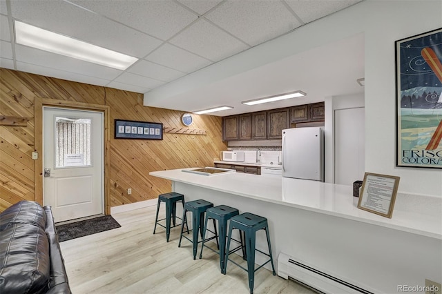 200 Granite St Unit 202, Frisco, CO 80443 - kitchen with white appliances, baseboard heating, a breakfast bar area, light countertops, and light wood-style flooring