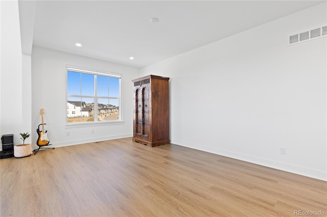 spare room featuring recessed lighting, light wood-style floors, visible vents, and baseboards