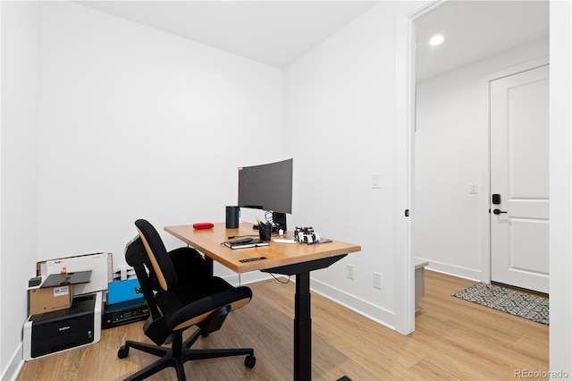 office space featuring light wood finished floors, recessed lighting, and baseboards