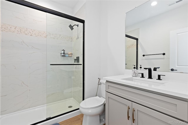 full bath with visible vents, toilet, a stall shower, wood finished floors, and vanity