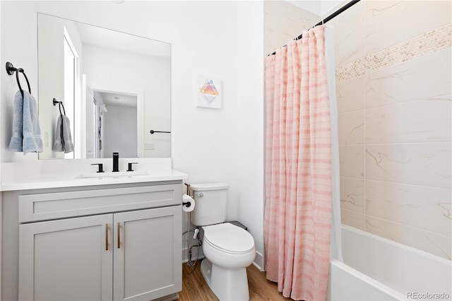 bathroom with vanity, toilet, wood finished floors, and shower / bath combo with shower curtain