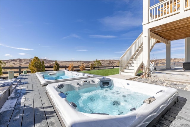 exterior space featuring stairs, a mountain view, and hot tub deck surround