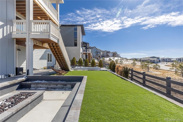 view of yard featuring stairway, fence, and a residential view