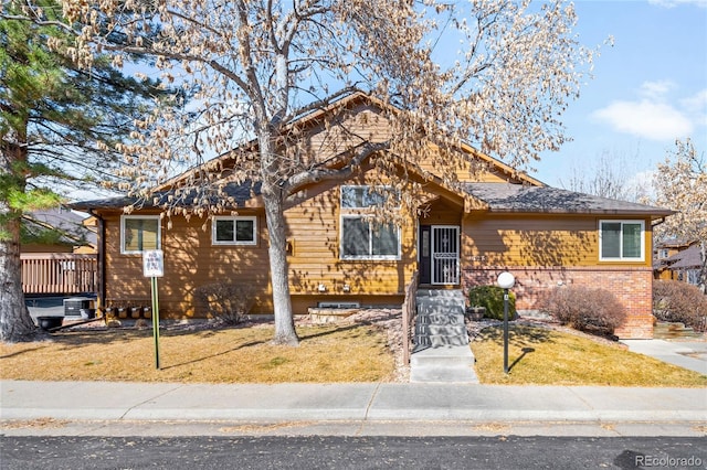 view of front of house with a front yard and brick siding