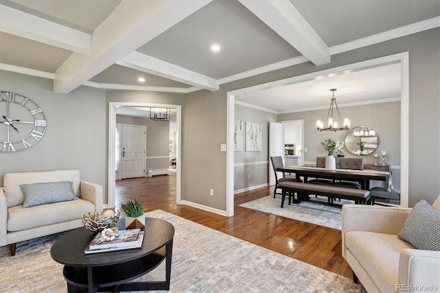 living area with a notable chandelier, a baseboard radiator, wood finished floors, beamed ceiling, and baseboards