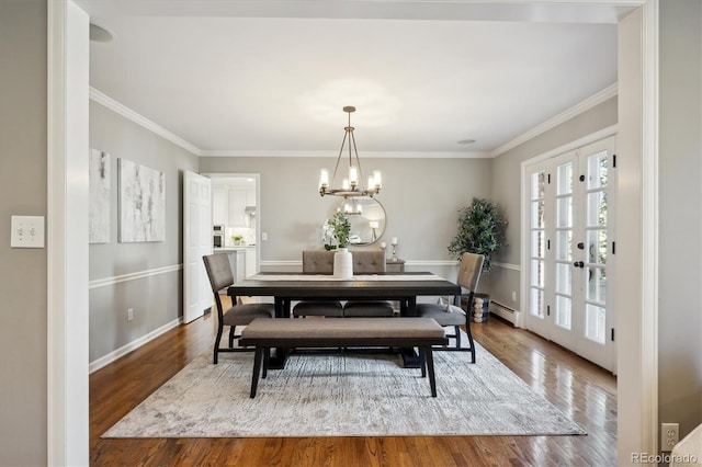 dining area with a baseboard radiator, french doors, a notable chandelier, and wood finished floors