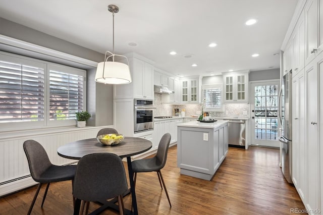 kitchen featuring under cabinet range hood, a kitchen island, white cabinetry, appliances with stainless steel finishes, and dark wood finished floors