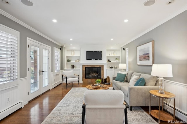 living area featuring built in features, french doors, a wainscoted wall, and baseboard heating