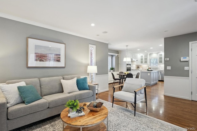 living area with baseboards, ornamental molding, wood finished floors, and recessed lighting