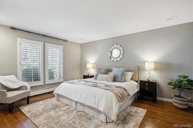 bedroom with baseboards, baseboard heating, and wood finished floors