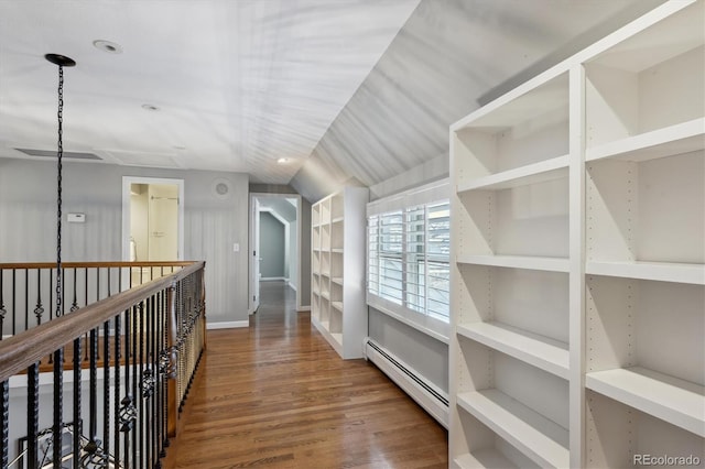 corridor featuring baseboards, a baseboard heating unit, and wood finished floors