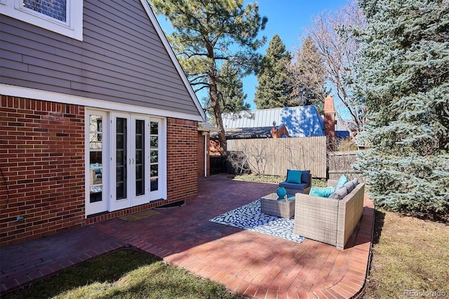 view of patio with french doors, fence, and an outdoor living space