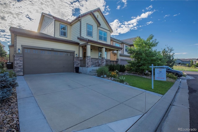 craftsman house with stone siding, a porch, driveway, and a garage