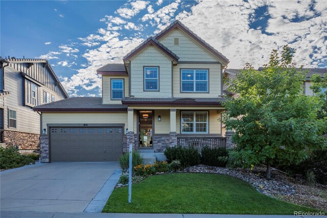 craftsman-style home featuring a garage, stone siding, concrete driveway, a front yard, and a porch