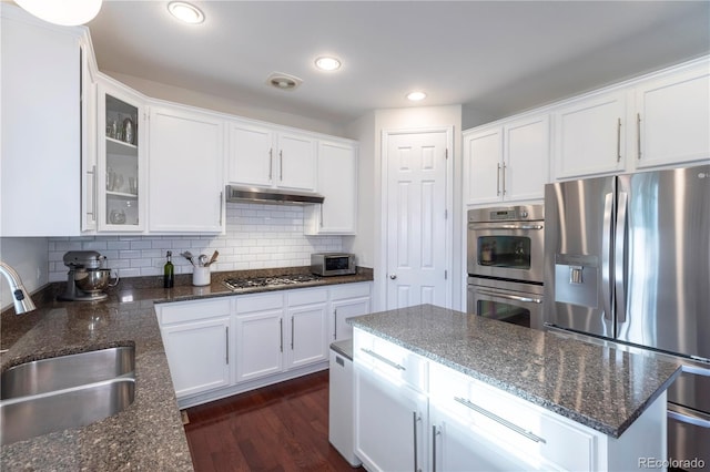 kitchen featuring a sink, under cabinet range hood, white cabinets, and appliances with stainless steel finishes