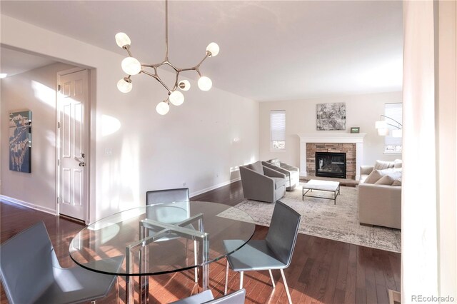 dining room with a fireplace, baseboards, dark wood-type flooring, and a healthy amount of sunlight