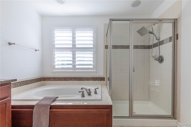 bathroom with a shower stall and a garden tub