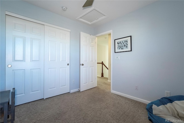 unfurnished bedroom with baseboards, a closet, attic access, and carpet
