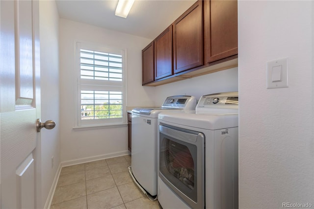 laundry room with washer and clothes dryer, light tile patterned flooring, cabinet space, and baseboards