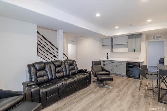 living area featuring indoor wet bar, visible vents, recessed lighting, light wood finished floors, and beverage cooler
