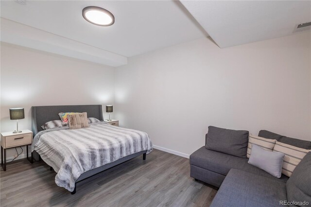 bedroom featuring baseboards, visible vents, and wood finished floors