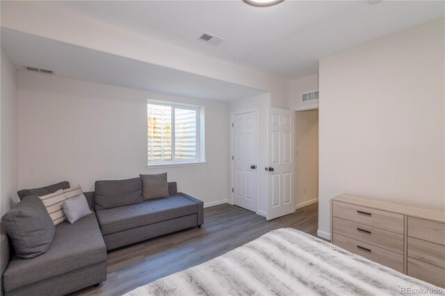 living area with baseboards, visible vents, and wood finished floors