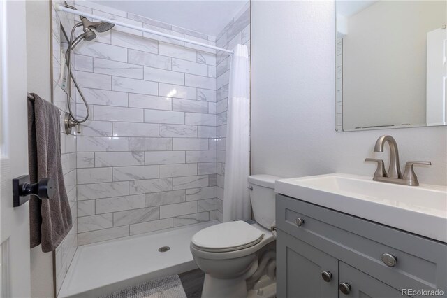 bathroom featuring a stall shower, vanity, and toilet