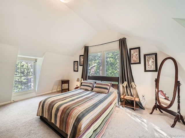 bedroom with vaulted ceiling, multiple windows, and light colored carpet