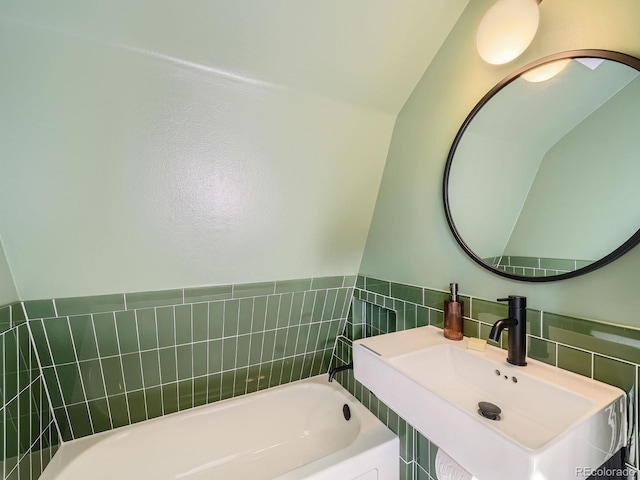 bathroom with tile walls, sink, and a bathing tub