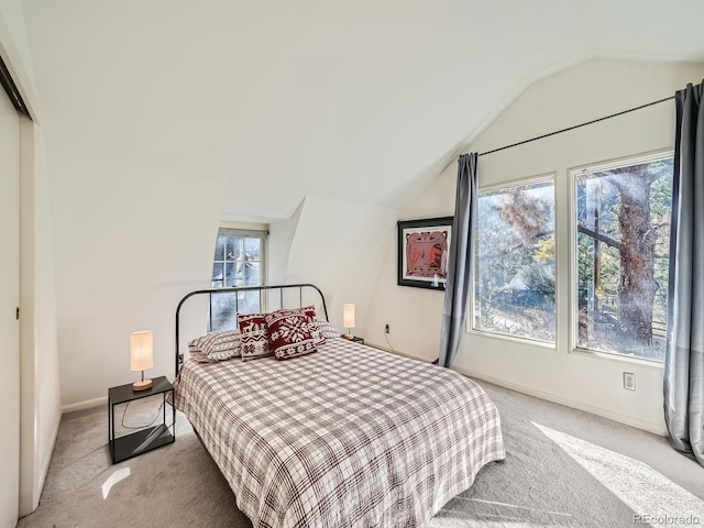 bedroom featuring multiple windows, light colored carpet, and vaulted ceiling