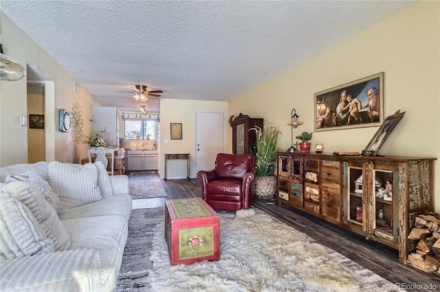 living room with dark hardwood / wood-style flooring, a textured ceiling, and ceiling fan